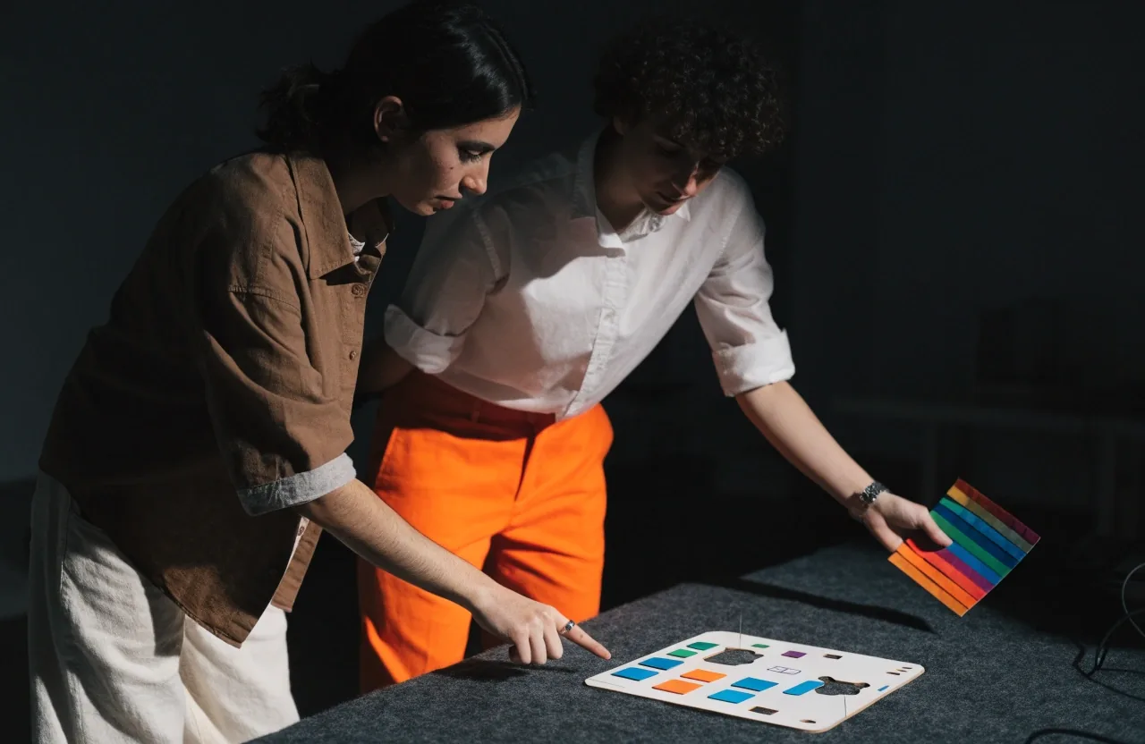 A hand placing a blank paper card on a charcoal felt table during a project planning session